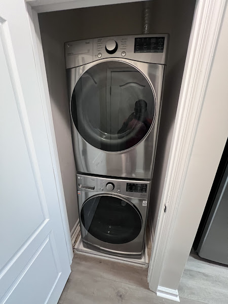 Stacked LG washer and dryer installed by Appliance Solutions in customer laundry closet
